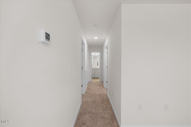 hallway featuring light colored carpet