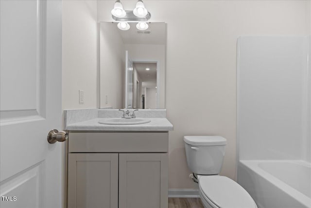 bathroom with hardwood / wood-style floors, vanity, and toilet