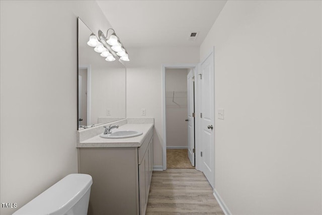 bathroom featuring hardwood / wood-style floors, vanity, and toilet