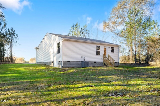 back of property featuring a yard and central air condition unit