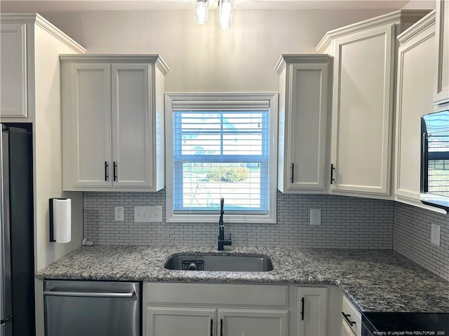 kitchen with backsplash, white cabinets, sink, light stone countertops, and appliances with stainless steel finishes