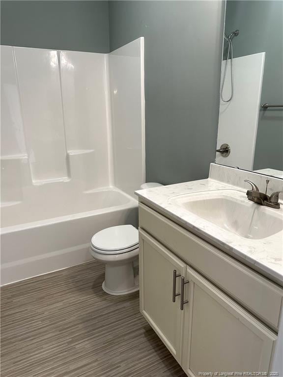 full bathroom featuring hardwood / wood-style flooring, vanity, toilet, and tub / shower combination