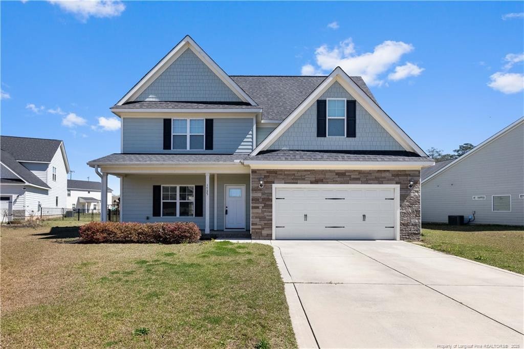 1725 Bluffside Dr, Fayetteville, NC 28312 - craftsman-style home featuring cooling unit, stone siding, concrete driveway, and a front lawn