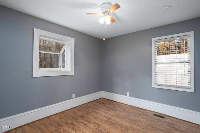 spare room with a textured ceiling, hardwood / wood-style flooring, and ceiling fan