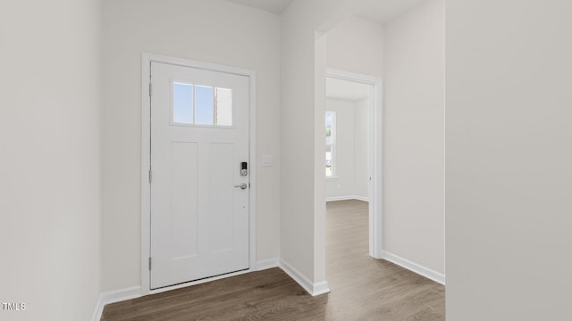 foyer featuring baseboards and wood finished floors