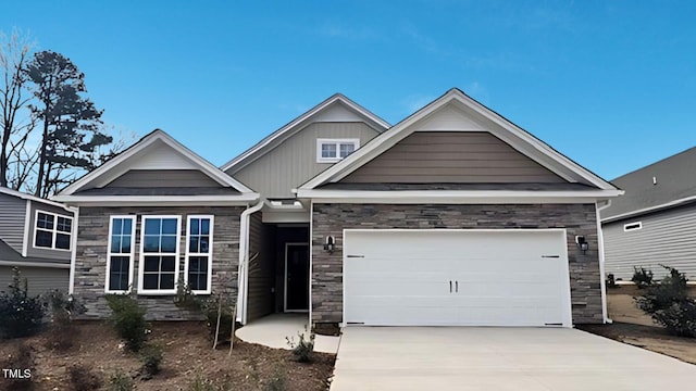 craftsman inspired home with a garage, stone siding, and driveway