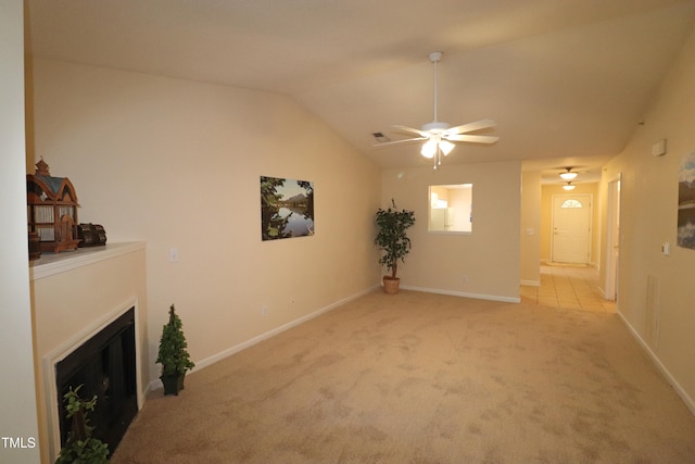 unfurnished living room with ceiling fan, light colored carpet, and vaulted ceiling