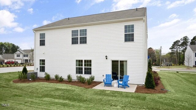 back of property featuring a lawn and a patio