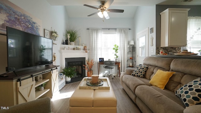 living room with vaulted ceiling, light hardwood / wood-style flooring, and ceiling fan