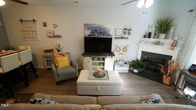 living room featuring wood-type flooring and ceiling fan