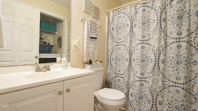 bathroom featuring vanity, curtained shower, and toilet