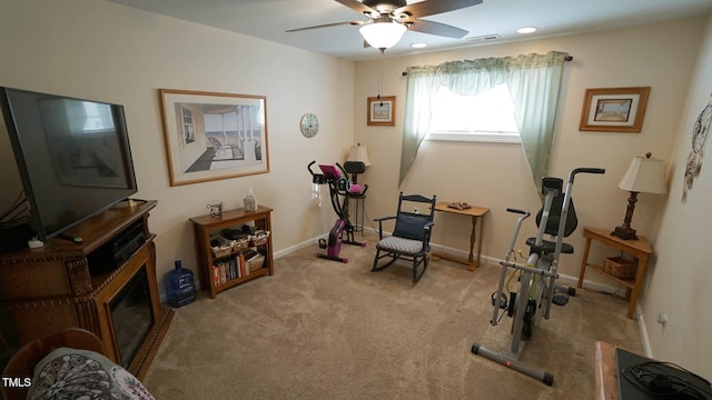 exercise area featuring light carpet and ceiling fan