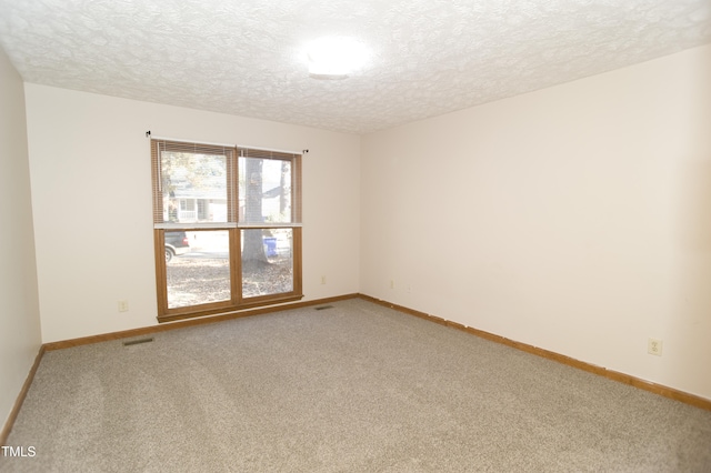 carpeted spare room featuring a textured ceiling