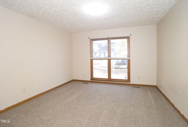 unfurnished room featuring carpet and a textured ceiling