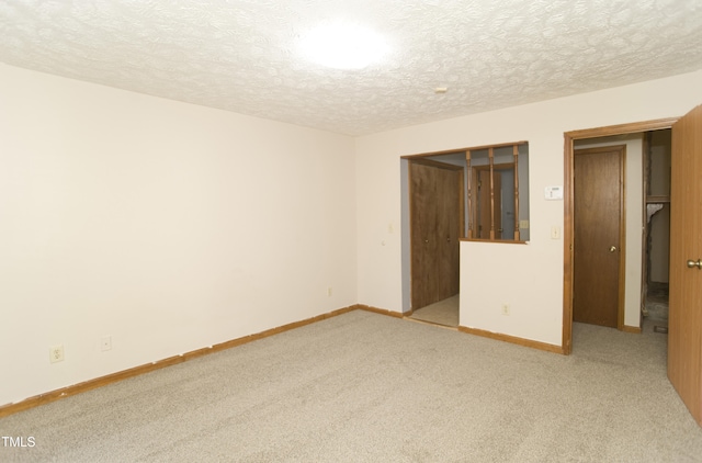 carpeted spare room featuring a textured ceiling