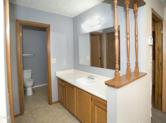 bathroom featuring tile patterned flooring, vanity, toilet, and a textured ceiling