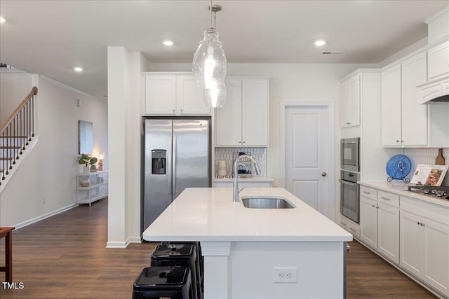 kitchen with dark hardwood / wood-style flooring, stainless steel appliances, a kitchen island with sink, and sink