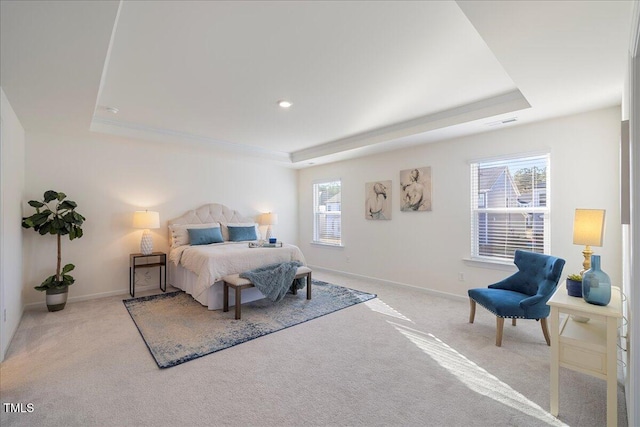 bedroom with light carpet and a raised ceiling