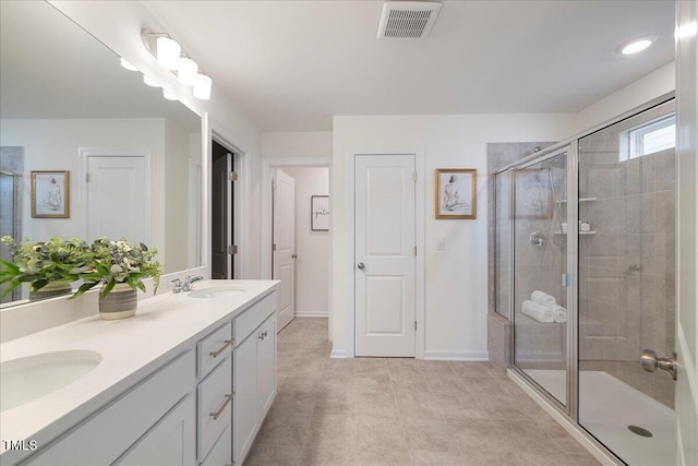 bathroom with tile patterned flooring, vanity, and a shower with shower door