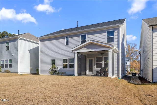 rear view of house with a yard and a sunroom