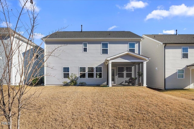 back of property with a sunroom and a yard