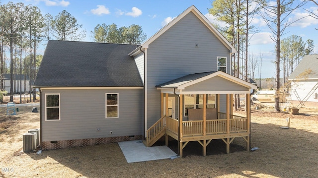 rear view of house with central AC unit and a sunroom