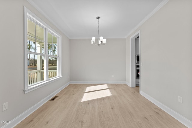 unfurnished dining area with ornamental molding, an inviting chandelier, and light hardwood / wood-style floors