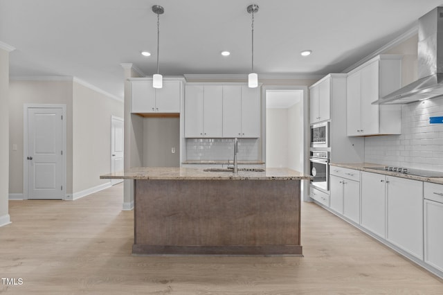 kitchen with hanging light fixtures, white cabinetry, a kitchen island with sink, and wall chimney exhaust hood