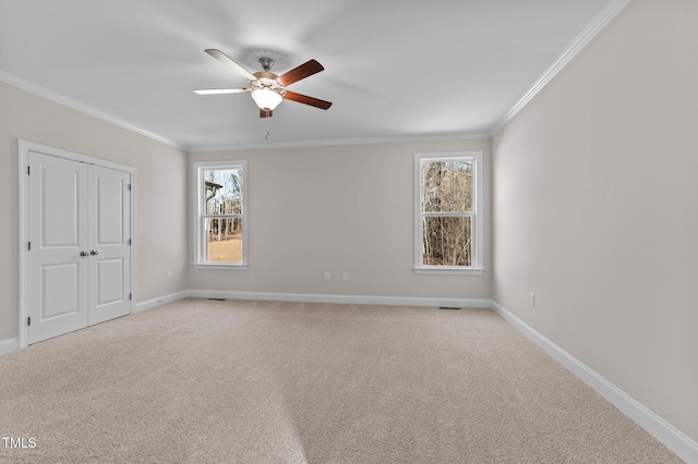 unfurnished room with ceiling fan, ornamental molding, and light carpet