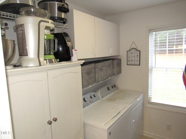 clothes washing area with cabinets and washer and clothes dryer