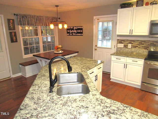 kitchen with sink, dark hardwood / wood-style floors, decorative backsplash, white cabinets, and appliances with stainless steel finishes