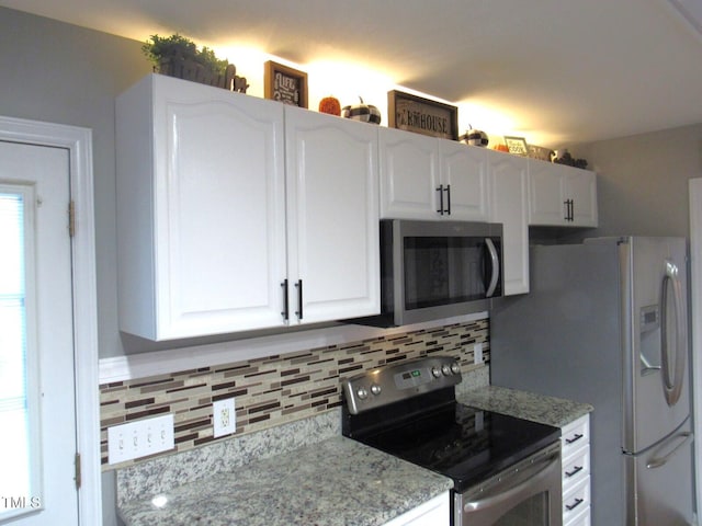 kitchen featuring backsplash, white cabinetry, light stone countertops, and stainless steel appliances