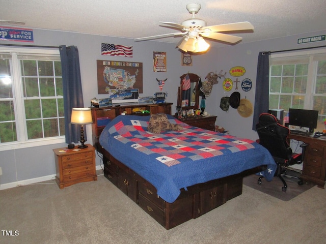 carpeted bedroom featuring multiple windows, a textured ceiling, and ceiling fan