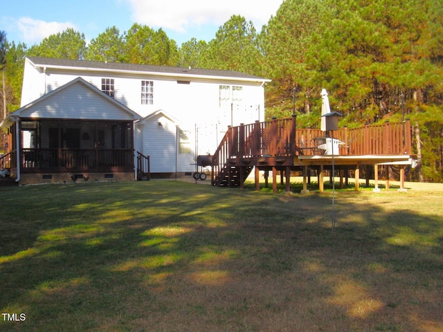 back of property featuring a sunroom, a deck, and a yard