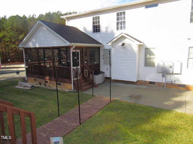 rear view of house with a sunroom and a yard