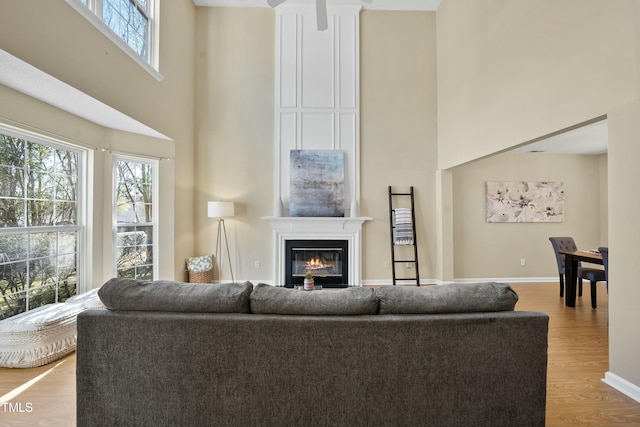 living room with a towering ceiling and light hardwood / wood-style floors