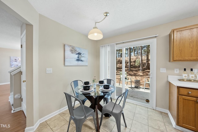 dining area featuring light tile patterned floors and a textured ceiling