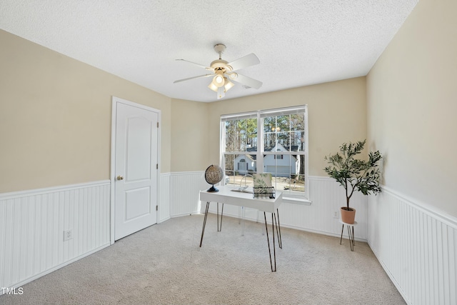 office featuring light carpet, ceiling fan, and a textured ceiling