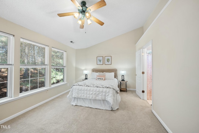 bedroom with light carpet, a textured ceiling, vaulted ceiling, and ceiling fan