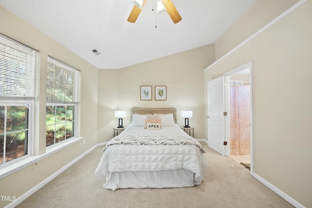 bedroom with light carpet, lofted ceiling, ceiling fan, and ensuite bathroom