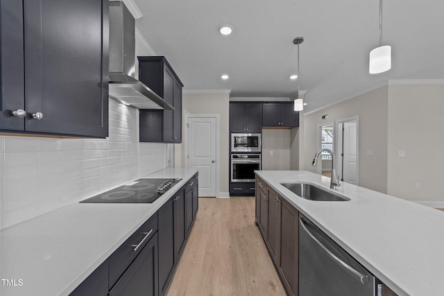 kitchen with appliances with stainless steel finishes, sink, hanging light fixtures, ornamental molding, and wall chimney range hood