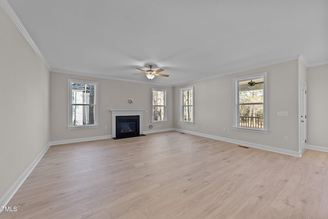 unfurnished living room with ornamental molding, a healthy amount of sunlight, and light wood-type flooring