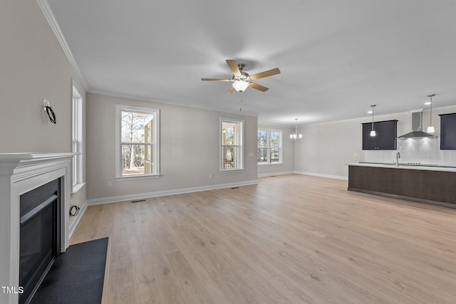 unfurnished living room with ornamental molding, ceiling fan, and light hardwood / wood-style flooring