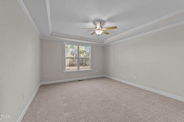 unfurnished room featuring crown molding, ceiling fan, a tray ceiling, and carpet flooring