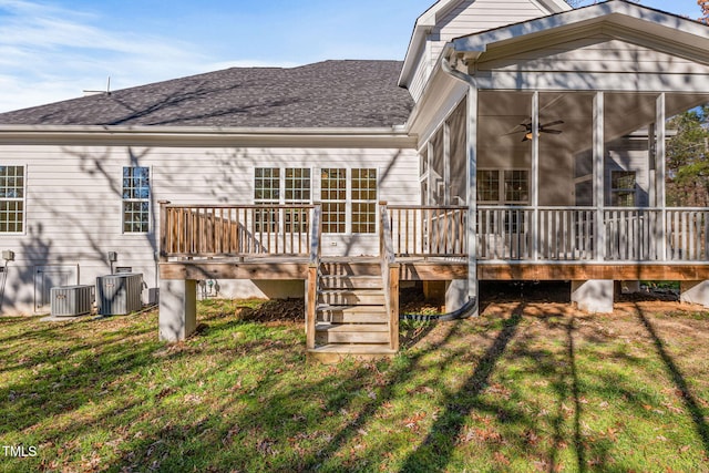 rear view of house with central air condition unit, a yard, a sunroom, and a wooden deck