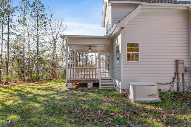 view of side of home with ceiling fan and a lawn