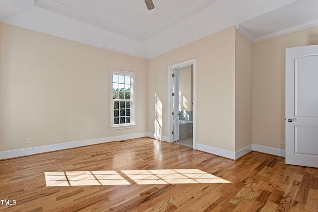 spare room featuring ornamental molding, ceiling fan, light hardwood / wood-style flooring, and a tray ceiling