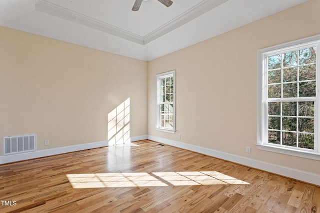 spare room featuring ornamental molding, ceiling fan, light hardwood / wood-style flooring, and a tray ceiling