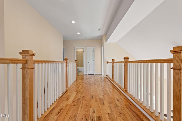 hallway with light wood-type flooring and lofted ceiling