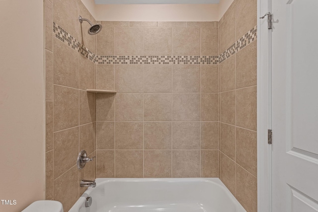 bathroom featuring toilet and tiled shower / bath combo